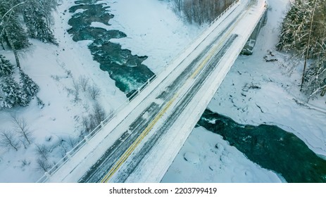 Aerial View Of A Bridge Connecting Two Roads Over A River During Winter