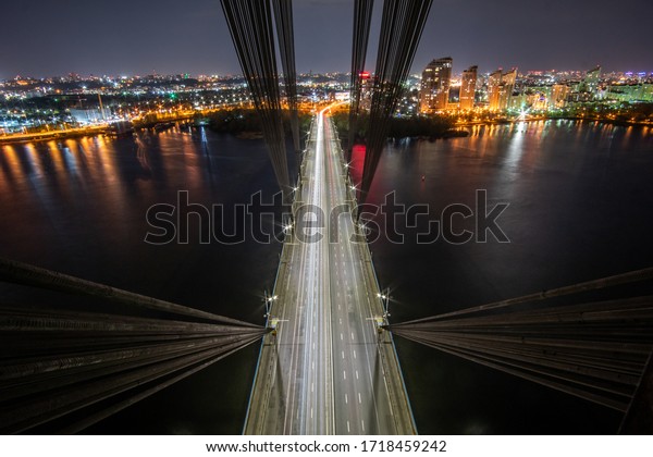 Aerial view of the bridge with the highway at\
night from the pylon of the cable-stayed bridge. View inside\
cable-stayed bridge.