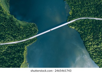 Aerial view of bridge road with red car over blue water lake or sea with island  and green woods in summer Finland. - Powered by Shutterstock