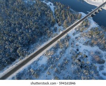 Aerial View Of A Bridge And A Straight Road Over River Nemunas In Small Town Merkine, Lithuania. Aerial Photography During Winter Season.