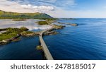 An aerial view of a bridge winding through a picturesque fjord in Norway, showcasing the stunning natural beauty of the region. Atlantic Ocean Road Norway