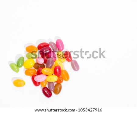 Aerial view of a bunch of colorful fruty jelly beans, isolated on white, with right space for text