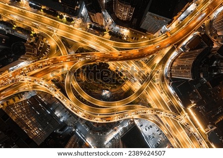 An aerial view of a bustling nighttime cityscape of a large intersection