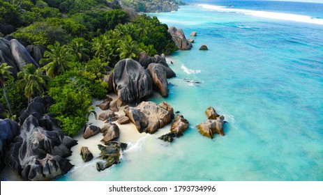 Aerial view by a drone of Anse Source d'Argent, La Digue Seychelles. Two people standing on a perfekt beach with a turquoise ocean and giant rocks in the background - Powered by Shutterstock