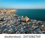 Aerial view of Cadiz city at sunset. View of city center with spectacular Cathedral of Cadiz in the middle. Medieval and historic city. Famous travel destination. Atlantic Ocean in background.