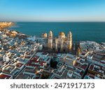 Aerial view of Cadiz city at sunset. View of city center with spectacular Cathedral of Cadiz in the middle. Medieval and historic city. Famous travel destination. Atlantic Ocean in background.