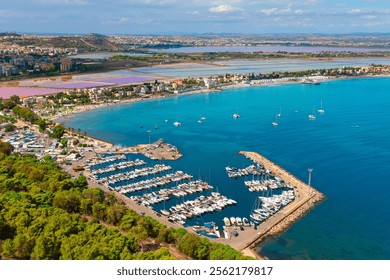 Aerial view of Cagliari, Sardinia, showcasing vibrant marina filled with yachts, turquoise waters and picturesque coastal town. Salt flats and distant hills complete scenic Mediterranean landscape - Powered by Shutterstock