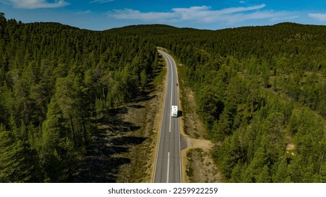 Aerial view of a camper driving in middle of forest, and tunturi mountains, in Inari, Lapland, Finland - Shutterstock ID 2259922259