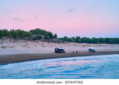 Aerial view, campervans and travellers, free camping on sandy beach against red evening sky, van life holiday, active  people traveling concept. Albania - Powered by Shutterstock