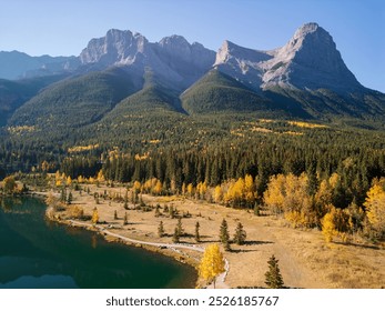 Aerial view of Canadian Rockies Autumn scenery in Quarry Lake, Canmore, Alberta, Canada. Yellow leaves forest, majestic mountains and blue sky reflected on the water. - Powered by Shutterstock