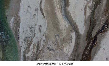 Aerial view of a canyon created by a river on a dried-up lake. Blue and green water and texture on the ground