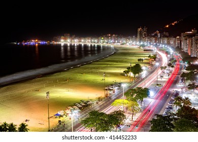 Aerial view of Capacabana Beach by night in Rio de Janeiro. The evening mist covers the shoreline, while cars leave long exposure light trails on Av. Atlantica - Powered by Shutterstock