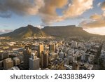 An aerial view of Cape Town central business district in late afternoon as the sun is setting, showing Table Mountain.