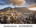 An aerial view of Cape Town central business district in late afternoon as the sun is setting, showing Table Mountain.