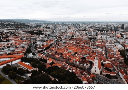 Aerial view of capital of Slovakia - Bratislava old town with downtown on background. Panoramic view of Bratislava city on moody and dark sunset with  orange rooftops and beautiful streets.