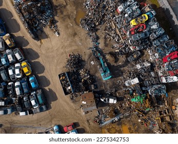 aerial view of a car dump, where a machine is seen separating old cars into scrap. - Shutterstock ID 2275342753
