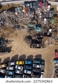 aerial view of a car dump, where a machine is seen separating old cars into scrap. - Shutterstock ID 2275342863