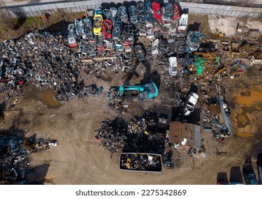 aerial view of a car dump, where a machine is seen separating old cars into scrap. - Shutterstock ID 2275342869
