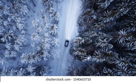 Aerial View Of A Car On Winter Road In The Forest. Aerial Photography Of Snowy Forest With Car On The Road. Aerial Photo. 