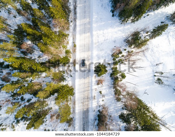 Aerial view of a car\
on winter road. Winter landscape countryside. Aerial photography of\
snow forest with a car on the road. Captured from above with a\
drone. Aerial photo. 