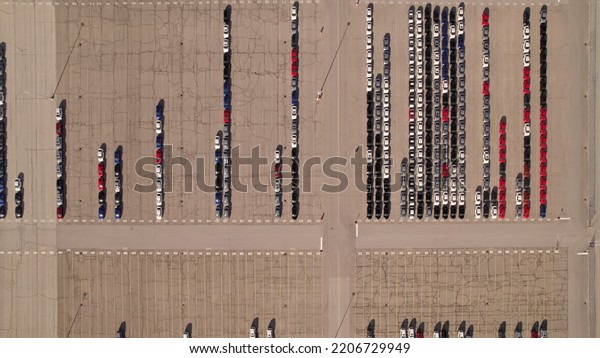 Aerial view of car storage or parking lot new unsold EV
cars. Vehicle automaker and manufacturer parking facility. Low
carbon footprint EV electric cars are ready for further
distribution. 
