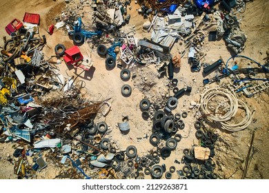Aerial view of car tyres, metal rods and other construction debris. Dump of various waste. Top down aerial view to scrap metal and tires at landfill