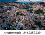 Aerial view of Caracas at sunset with the Petare neighborhood, the largest slum in Venezuela and latin america, with the Avila Mountain in the background.