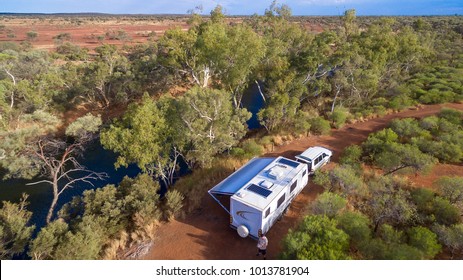 Aerial View Of Caravan And Four Wheel Drive Vehicle Camped Next To A River Pool In The Outback Of Australia