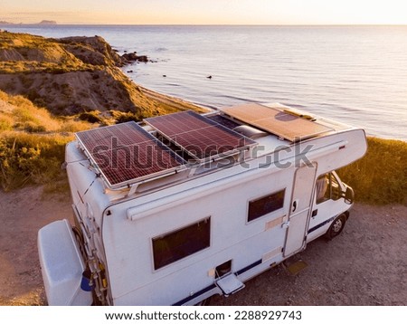Aerial view. Caravan with solar photovoltaic panels on roof camping on cliff sea shore. Mediterranean region of Villaricos, Almeria, eastern Andalusia, Spain.