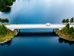Aerial View Caravan Trailer Or Camper Rv On The Bridge Over The Lake In Finland. Summer Holiday Trip.