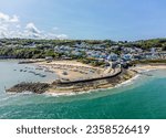 An aerial view from Cardigan Bay towards the harbour and the town at New Quay, Wales in summertime