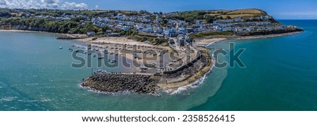 An aerial view from Cardigan Bay towards the harbour, town and headland at New Quay, Wales in summertime