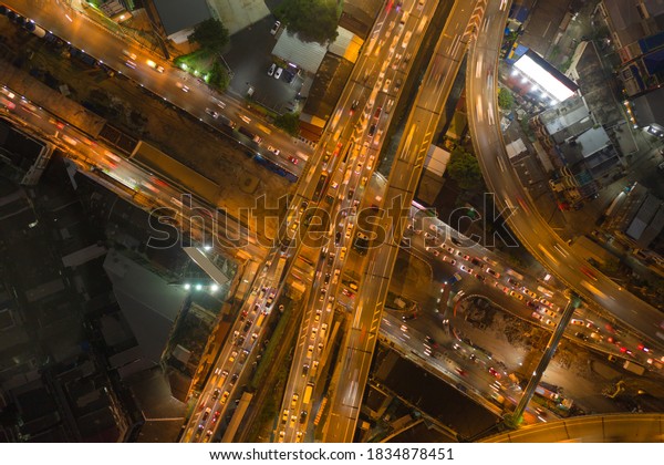 Aerial view of cars driving\
on highway junctions. Bridge street roads in connection network of\
architecture concept. Top view. Urban city, Bangkok at night,\
Thailand.