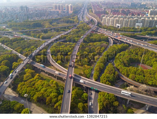 Aerial view of cars\
on highway junctions. Bridge roads or streets in structure of\
architecture and transportation concept. Top view. Urban city,\
Shanghai at noon, China.