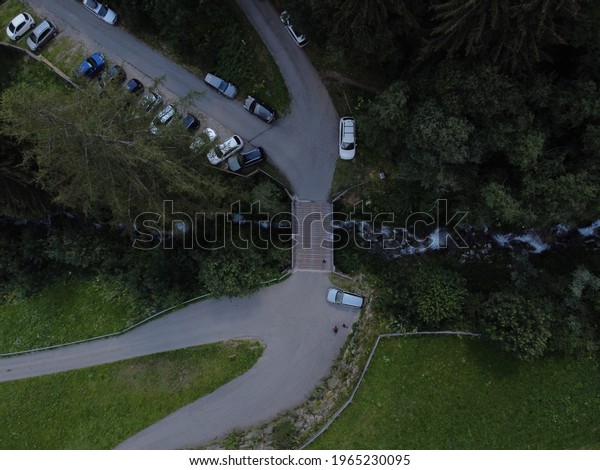 An aerial view of cars parked along the highway\
surrounded by trees