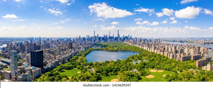 Aerial view of the Central park in New York with golf fields and tall skyscrapers surrounding the park.