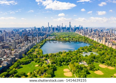 Aerial view of the Central park in New York with golf fields and tall skyscrapers surrounding the park.