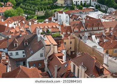 Aerial view of charming Prague rooftops with red tiles and lush park, capturing historical essence of european city on sunny summer day - Powered by Shutterstock