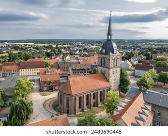 Aerial view of a charming village with a historic church, red tiled roofs, half-timbered houses and picturesque countryside. - Powered by Shutterstock