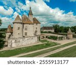 Aerial view of Chateau de Beauvoir restored medieval French castle with bridge, towers, manicured lawn and garden