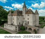 Aerial view of Chateau de Beauvoir restored medieval French castle with bridge, towers, manicured lawn and garden