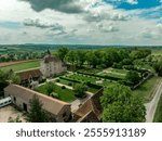 Aerial view of Chateau de Beauvoir restored medieval French castle with bridge, towers, manicured lawn and garden