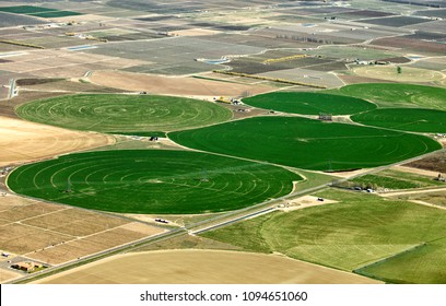 An aerial view of the circles created in farmland with pivot sprinklers watering the fields.
