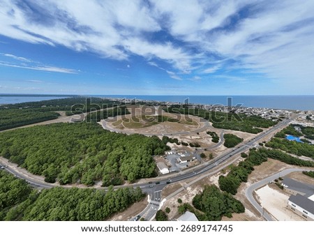 Aerial View Of Circular Road Loop Surrounding Hilltop Wright Brothers Monument With Outer Banks Coastline In Distance
