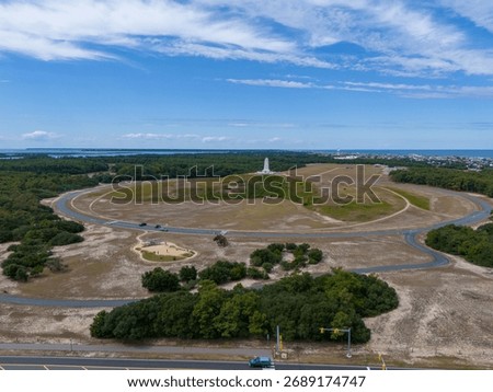 Aerial View Of Circular Road Loop Surrounding Hilltop Wright Brothers Monument With Outer Banks Coastline In Distance
