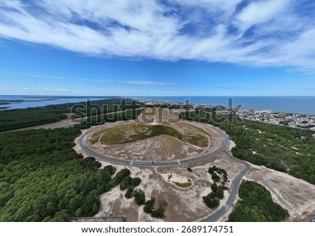 Aerial View Of Circular Road Loop Surrounding Hilltop Wright Brothers Monument With Outer Banks Coastline In Distance