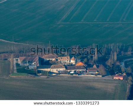 Similar – A tractor turns mown hay in a field in a small community