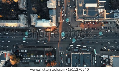 Aerial view of city intersection with many cars and GPS navigation system symbols. Autonomous driverless vehicles in city traffic. Future transportation concept.