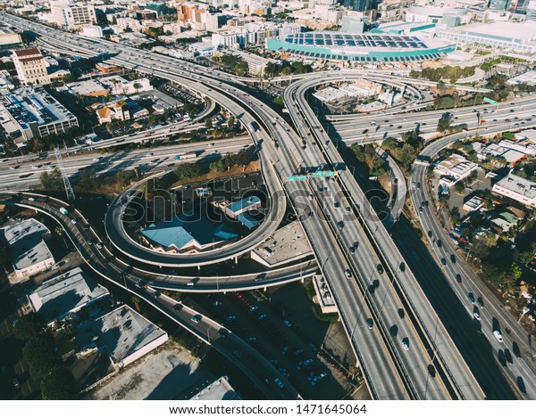 Aerial view of city landscape with autobahn\
motorway in metropolis, Bird\'s eye view. automobiles moving at\
street with modern automotive expressway. interchange road highway,\
junctions freeway