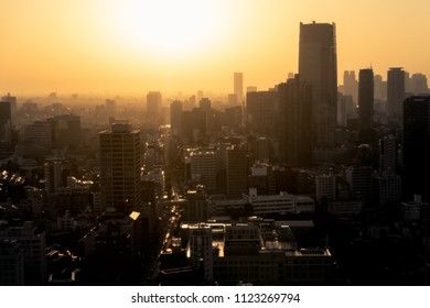 Aerial View Of A City Skyline At Sunset With Haze